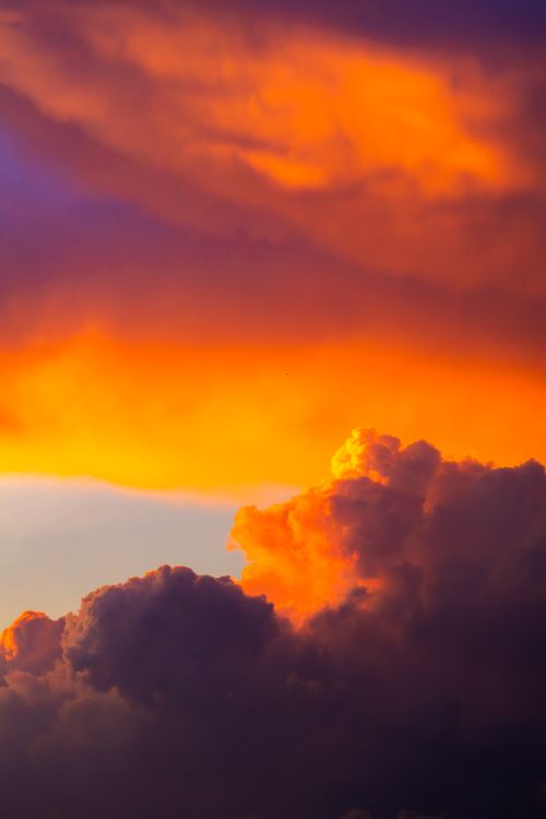 Free A striking view of colorful sunset clouds creating a dramatic sky at dusk. Stock Photo