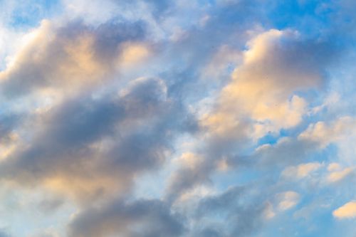 Free A tranquil view of soft, fluffy clouds against a colorful sunset sky. Stock Photo