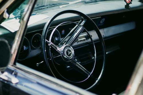 Free Close-up of a vintage car's steering wheel, showcasing classic design. Stock Photo