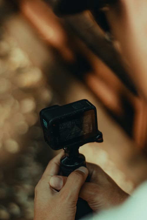 Free Close-up of a person holding an action camera outdoors, capturing nature scenes. Stock Photo