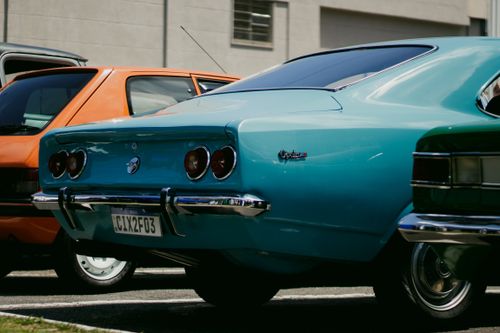 Free Close-up of vintage cars parked outdoors, showcasing retro design and vibrant colors. Stock Photo
