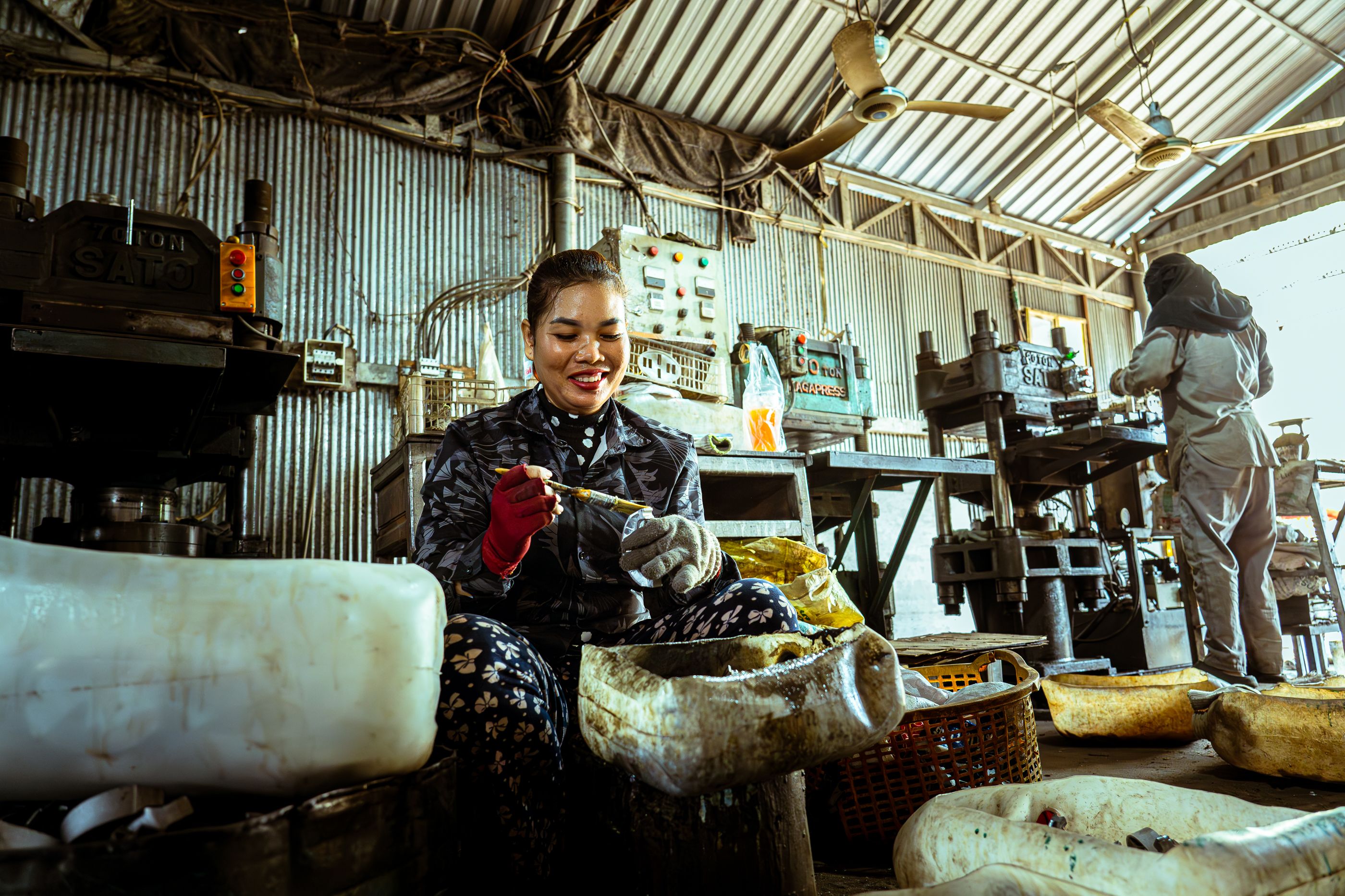 Smiling woman working with equipment in an industrial workshop