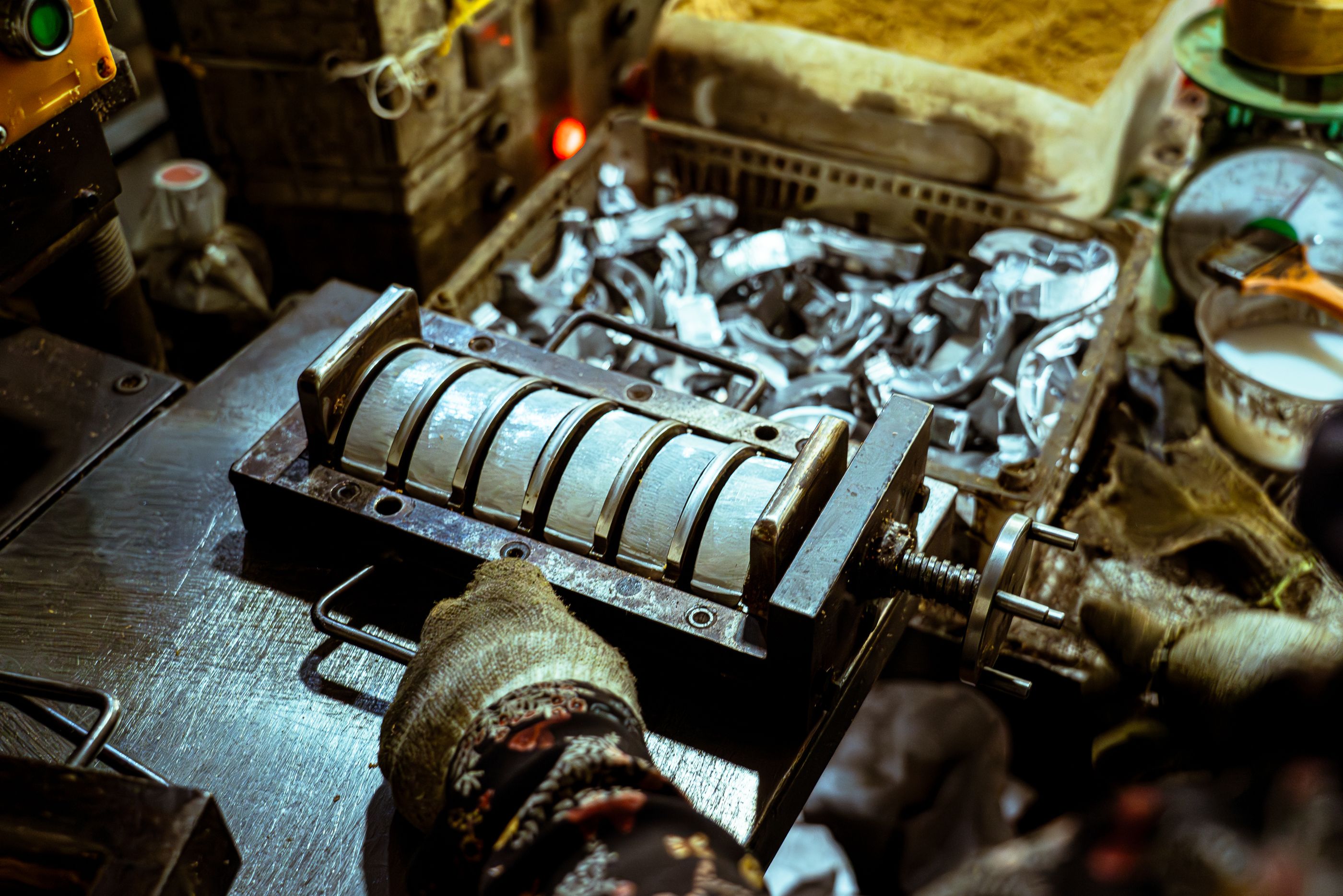 Worker operating a metal bending machine in a workshop.