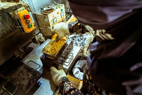 Free A person wearing gloves operating a machine in a food processing plant. Industrial setting. Stock Photo