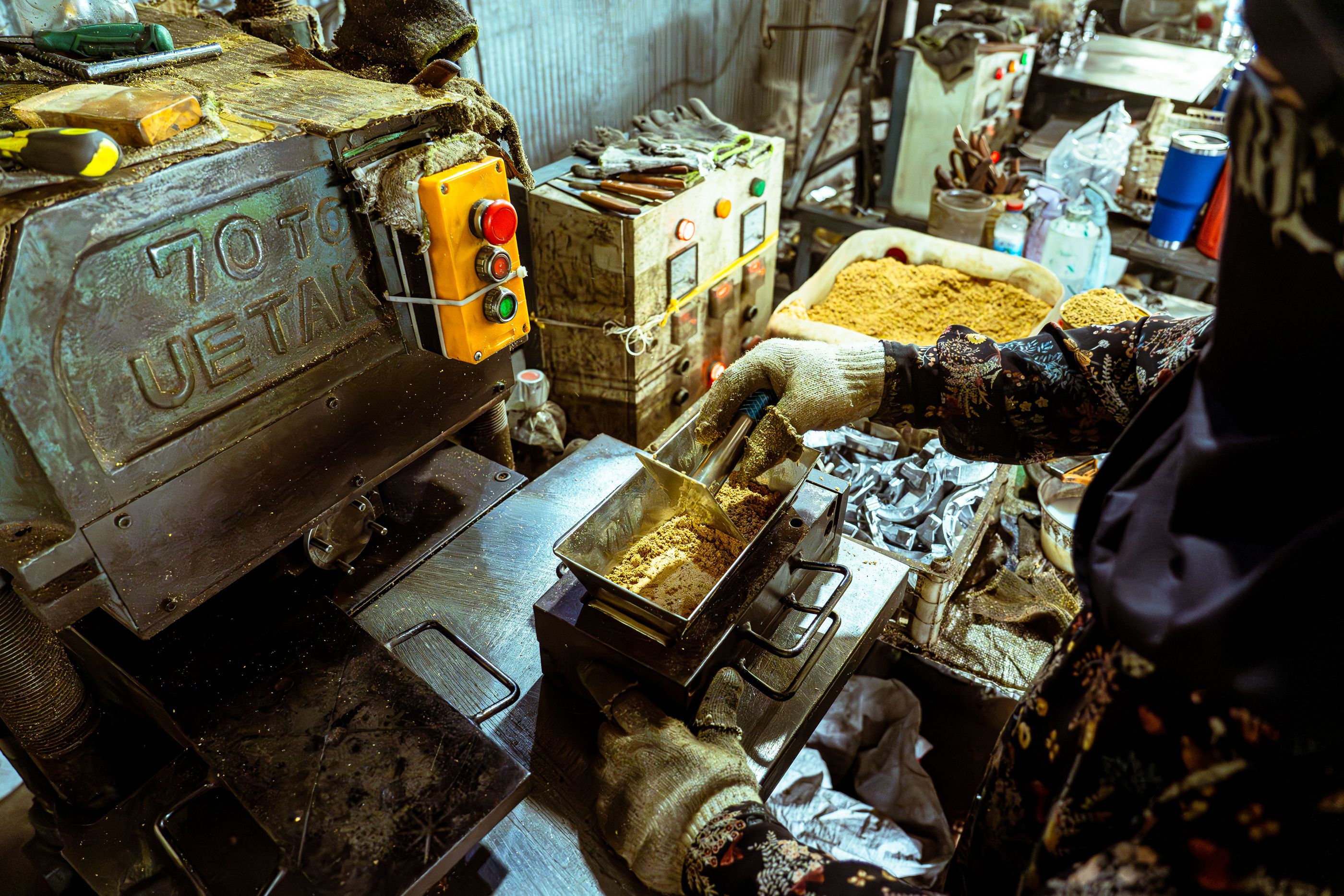 Factory scene showing a worker operating machinery with raw materials, highlighting industrial processes.