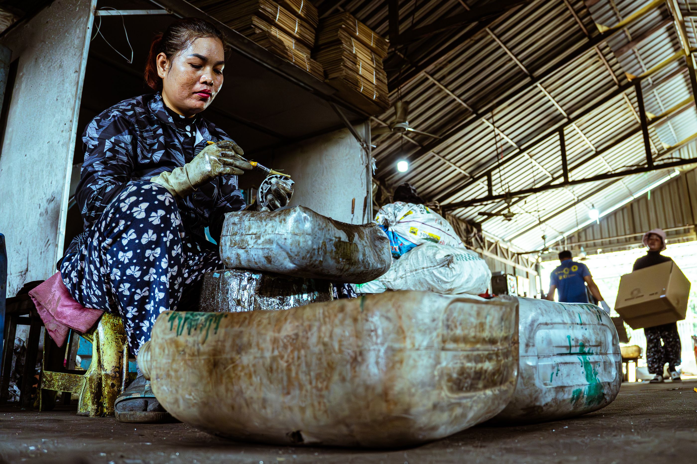Woman sorting recycled materials in an industrial facility