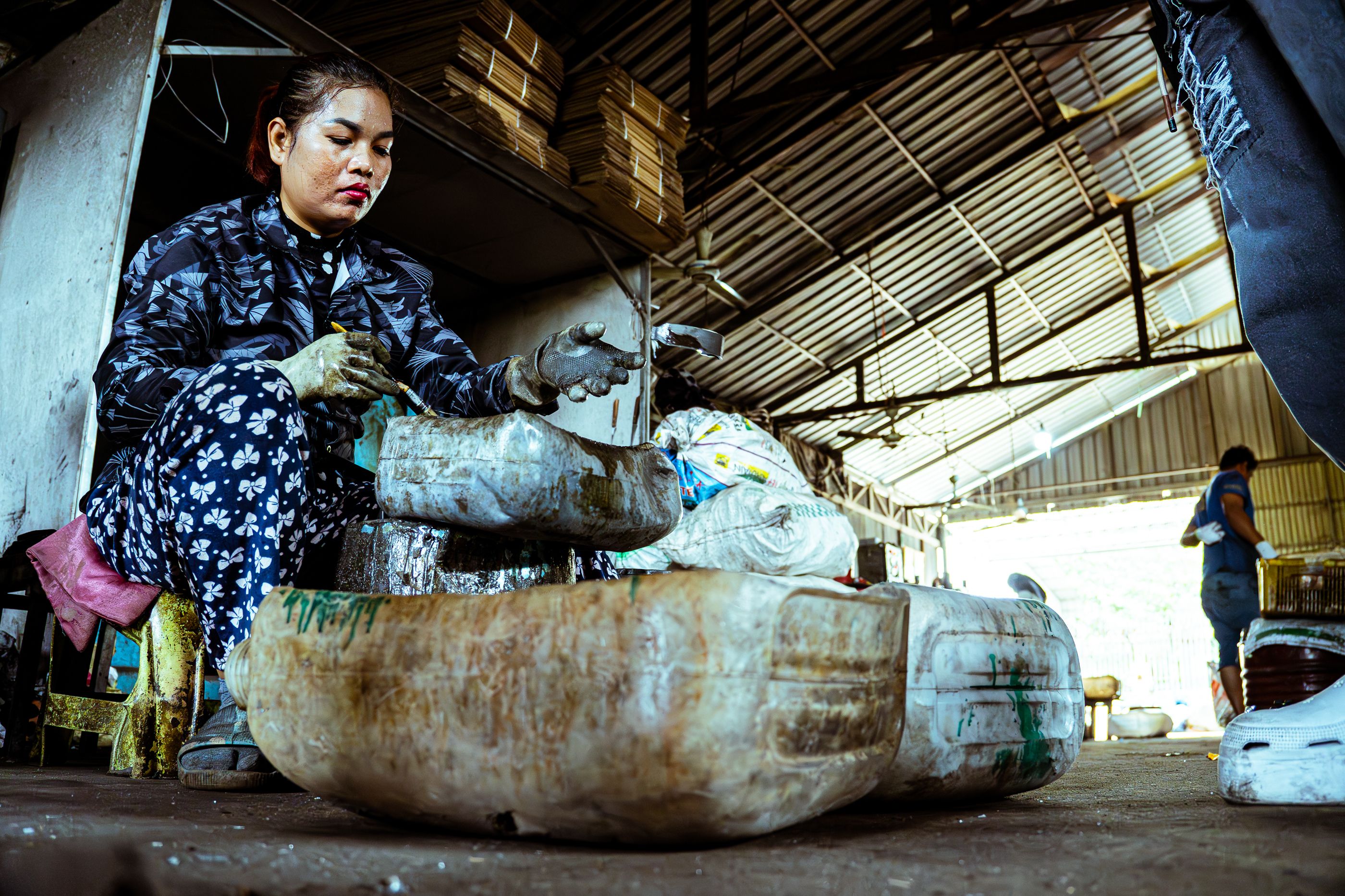 Woman processing materials at an industrial recycling facility