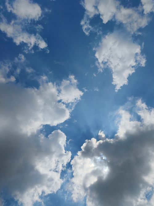 Free A serene view of fluffy white clouds against a clear blue sky in Silchar. Perfect for nature and travel themes. Stock Photo