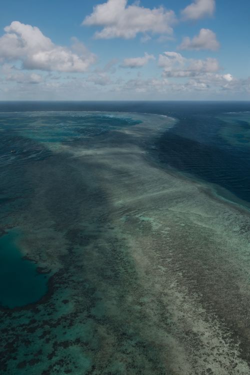 Free Aerial view of the stunning Great Barrier Reef showcasing vibrant coral colors and clear blue waters. Stock Photo