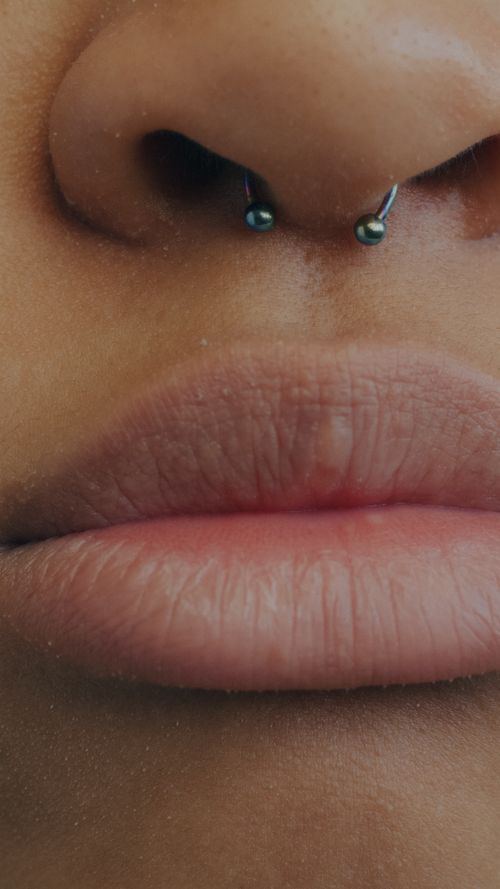 Free A detailed close-up image focusing on a person's pierced nose and lips. Stock Photo