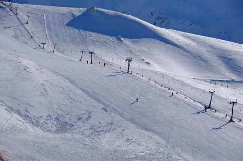 Free Aerial view of a snowy ski slope in Isparta, Türkiye with few skiers present. Stock Photo
