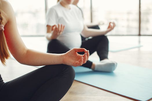 Pregnant women practicing yoga and meditation in a serene studio setting.