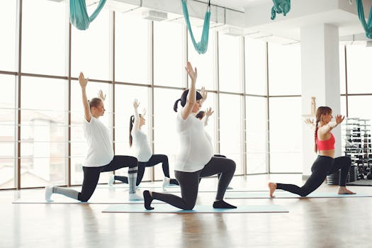 Group of women practicing prenatal yoga in a sunny, modern studio.