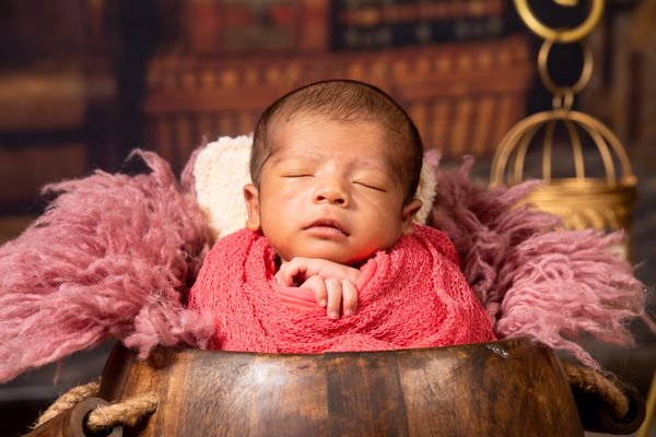 Sleeping newborn in a pink wrap