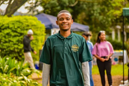 Free A young man smiles outdoors in Manzini, Eswatini, enjoying a community gathering. Stock Photo