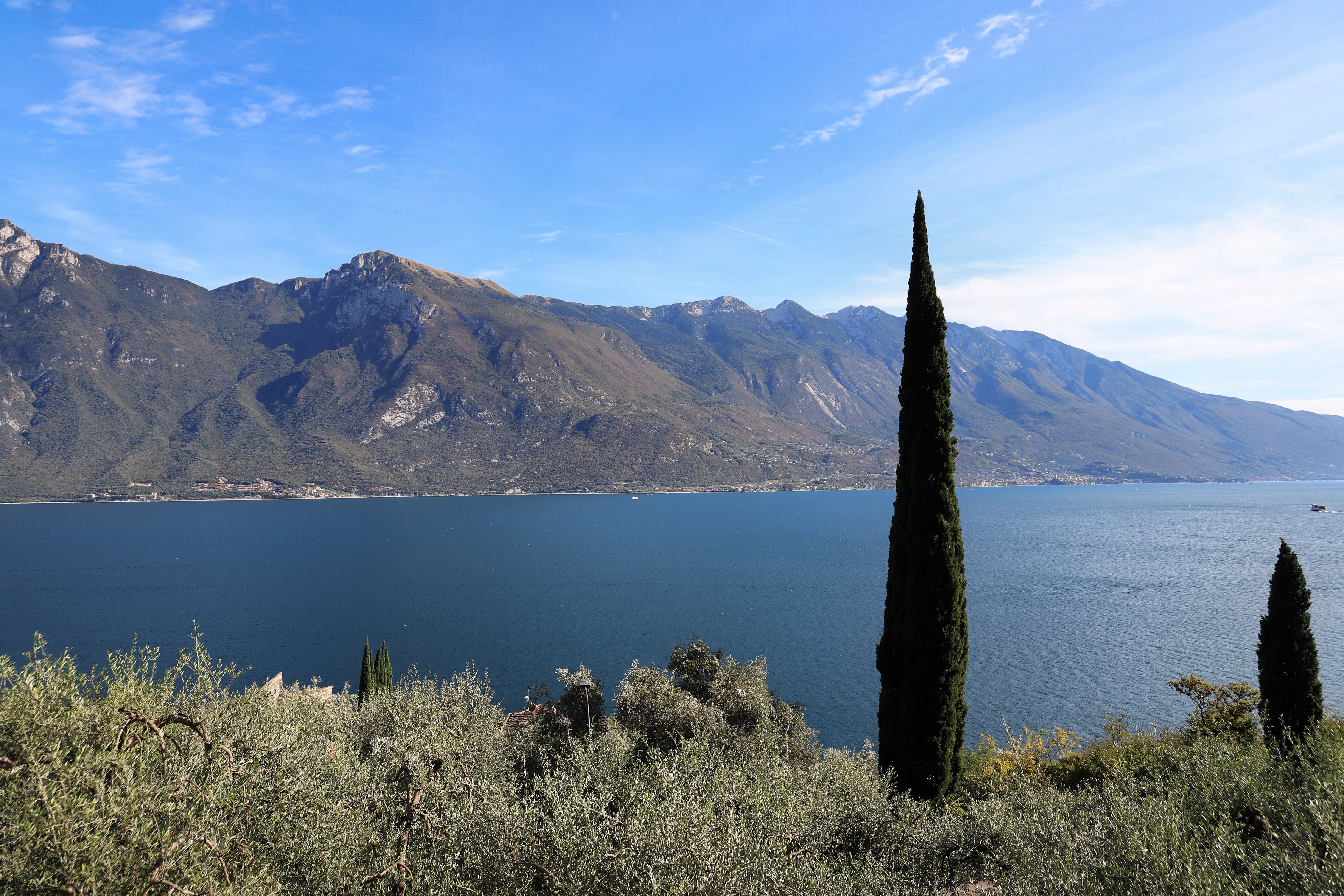 Beautiful landscape of Lake Garda with cypress trees and mountains in Limone Sul Garda, Italy.