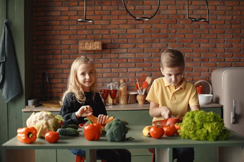 Free Children in the Kitchen Slicing Vegetables Stock Photo