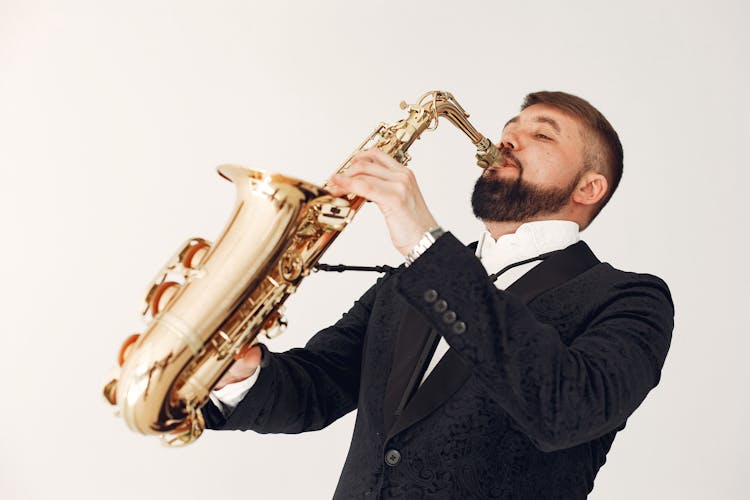 Man In Black Suit Playing Baritone Saxophone