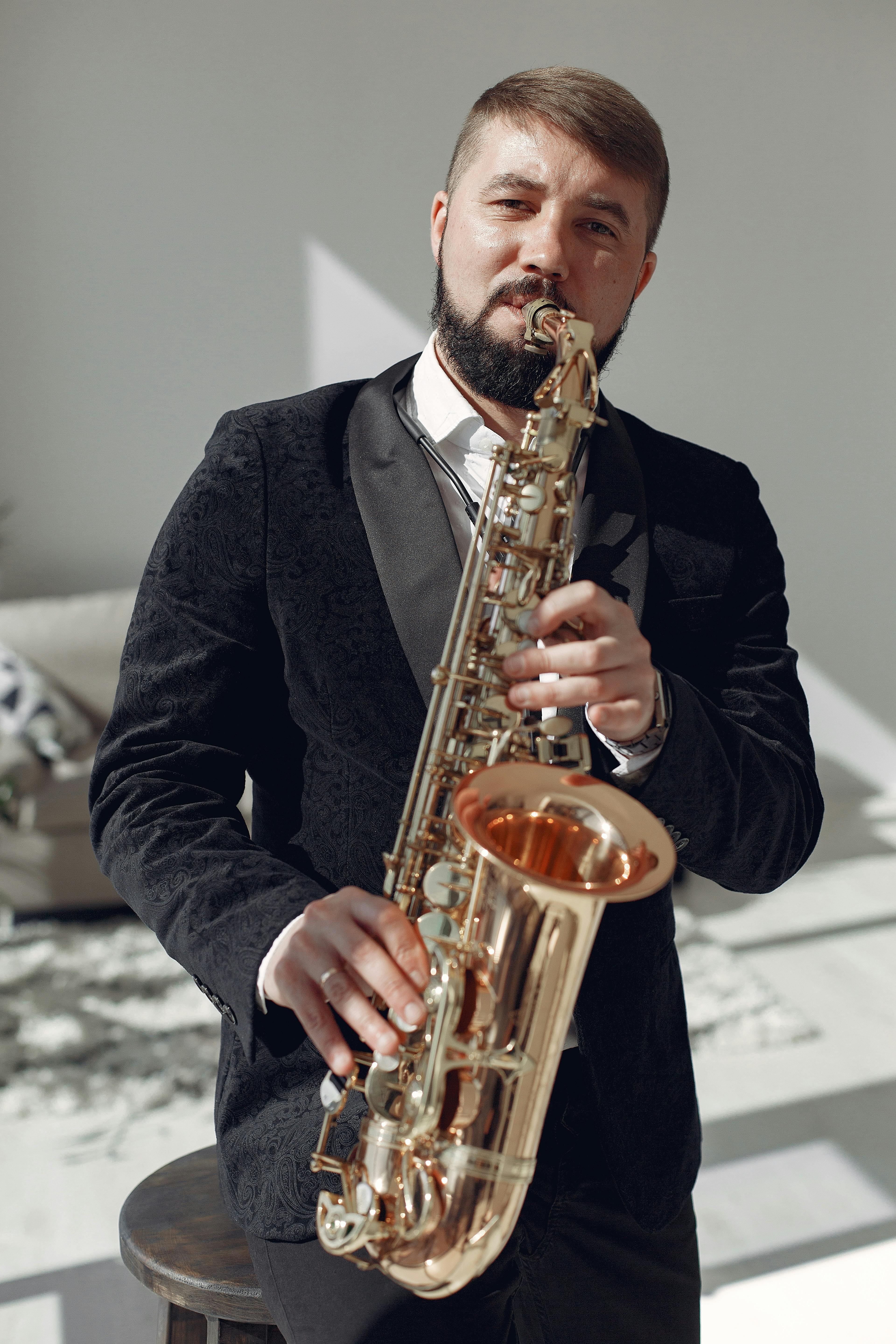 adult man playing saxophone on concert