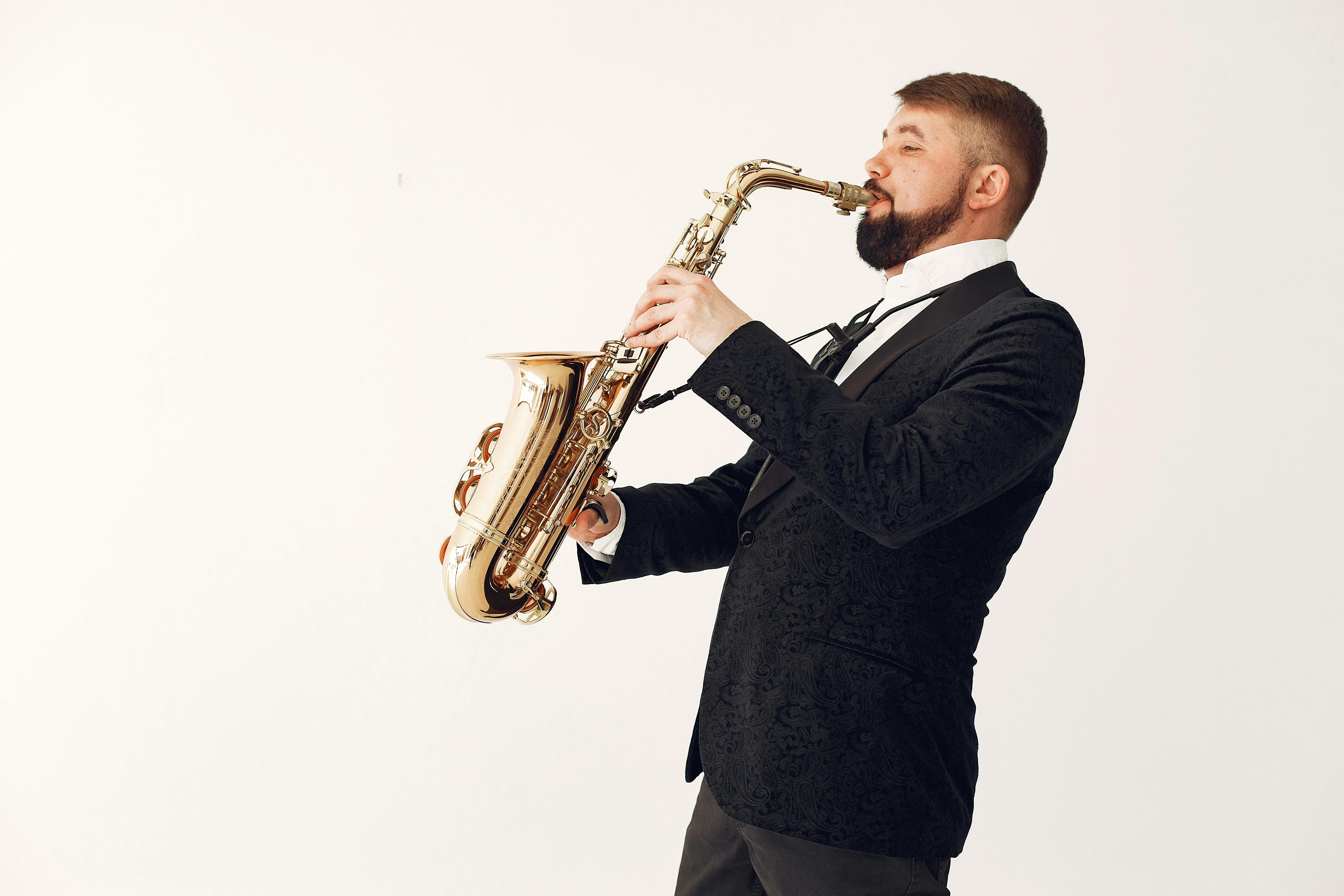 adult man playing saxophone during rehearsal isolated on white background