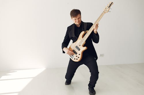Man in Black Suit Playing Electric Guitar