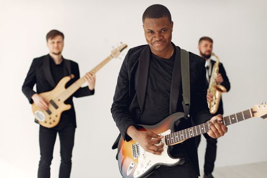 Dynamic live concert featuring male musicians with guitars and saxophone.