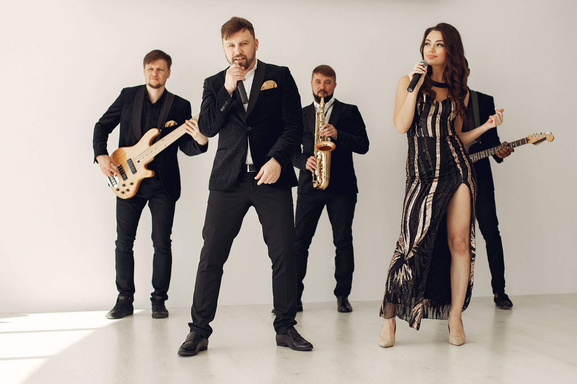 Corporate Event DJ vs Live Band: Choose With Confidence A stylish music band performing with vocalists and musicians in formal attire.