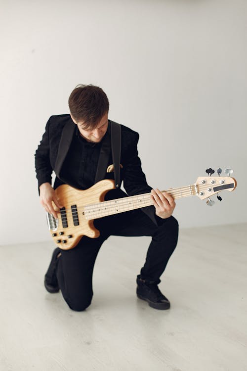 Man in Black Suit Playing White Electric Guitar