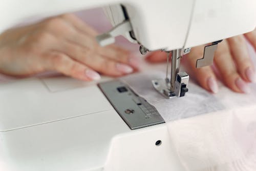 Free Person Sewing with a White Sewing Machine Stock Photo