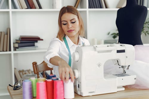 Free Dressmaker in front of her Sewing Machine Stock Photo