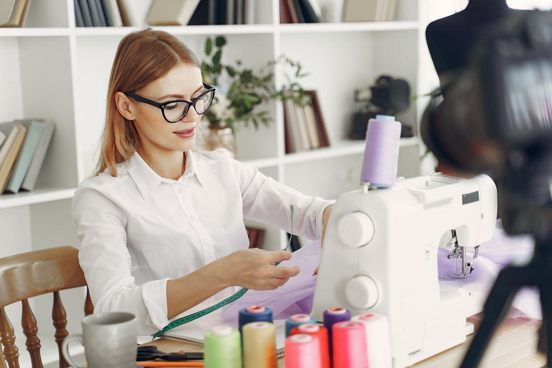 Woman in Black Framed Eyeglasses Sitting Beside Sewing Machine · Free ...