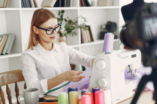 A fashion designer working with a sewing machine in a studio, creating stylish clothing pieces.