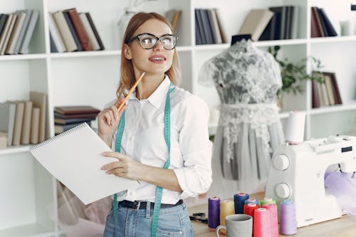 Woman in White Button Up Shirt Holding White Sketchpad