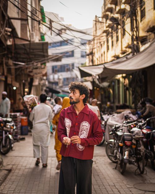 Free Man explores a bustling street market in Old Karachi, Pakistan, capturing local culture. Stock Photo
