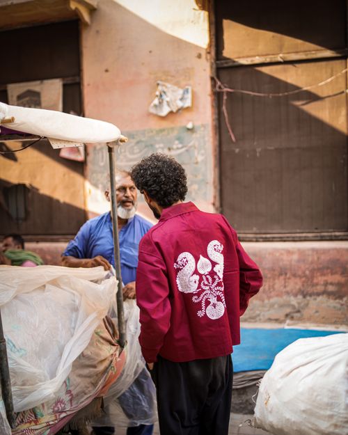 Free Two men interacting at a market stall in Pakistan, showcasing local street life. Stock Photo