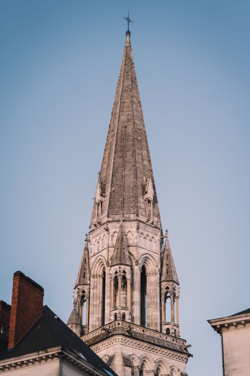 Free Detailed view of a Gothic church steeple with a clear blue sky background. Stock Photo