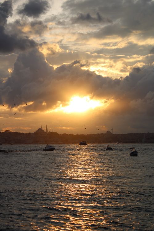 Free Stunning sunset over the Bosphorus in Istanbul with boats silhouetted against the golden sky. Stock Photo