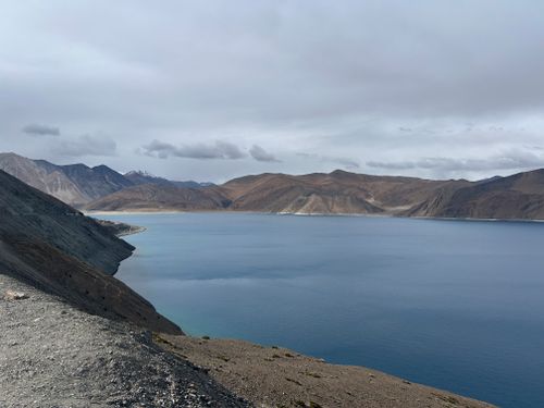 Free Breathtaking view of Pangong Lake in Ladakh, surrounded by mountains under a cloudy sky. Stock Photo