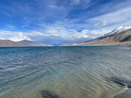 Free Breathtaking view of Pangong Lake with snow-capped mountains under a vibrant blue sky. Stock Photo