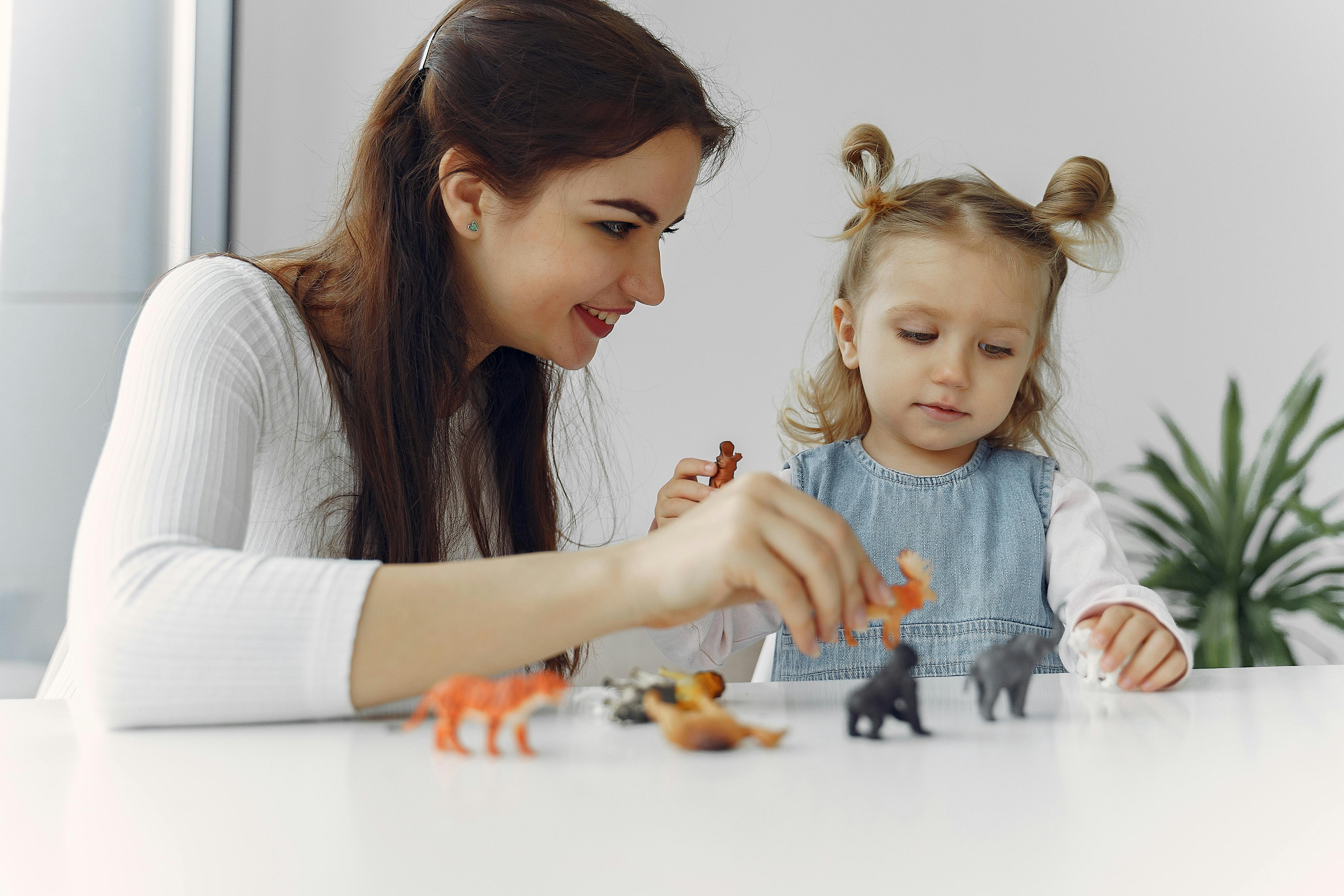 young cheerful woman playing with cute daughter