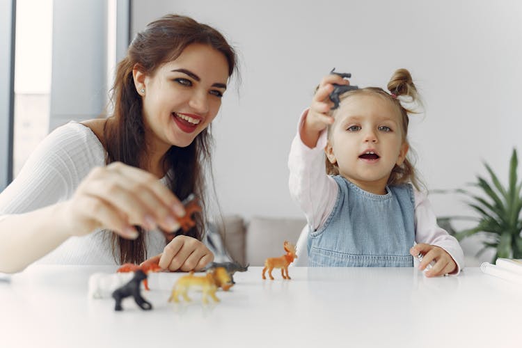 Little Girl Playing Animal Figures With Her Mother