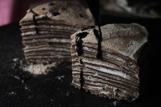 Indulgent chocolate crepe layer cake topped with a rich chocolate drizzle, perfect for dessert lovers.