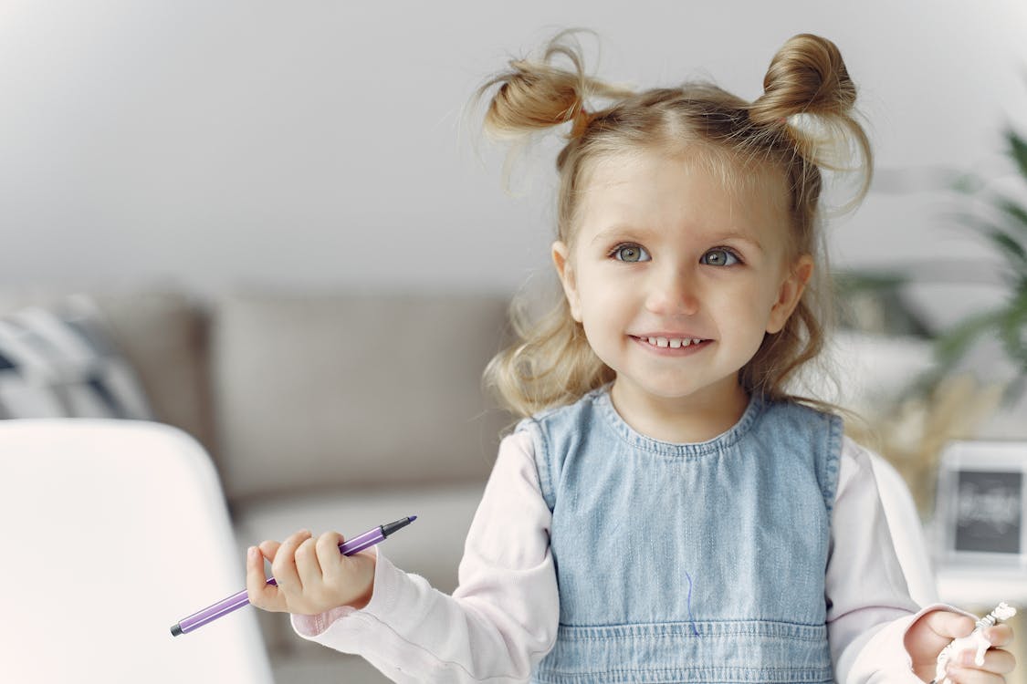 Free Cute Little Girl Holding Purple Color Pen Stock Photo