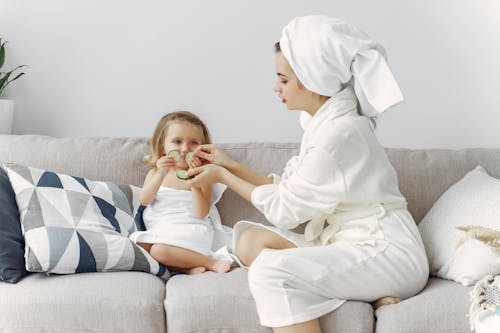 Free Photo of Mother and Daughter Sitting on Gray Couch Stock Photo