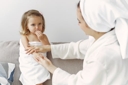 Mother Applying Moisturizer to Her Daughters Hand