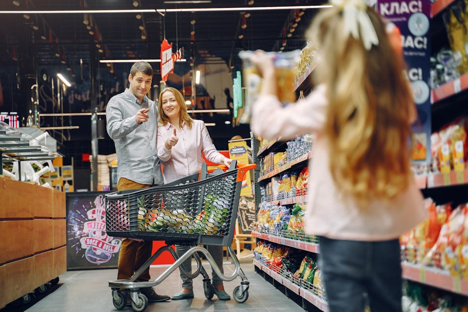 Happy family shopping in supermarket aisle with daughter holding snack box.