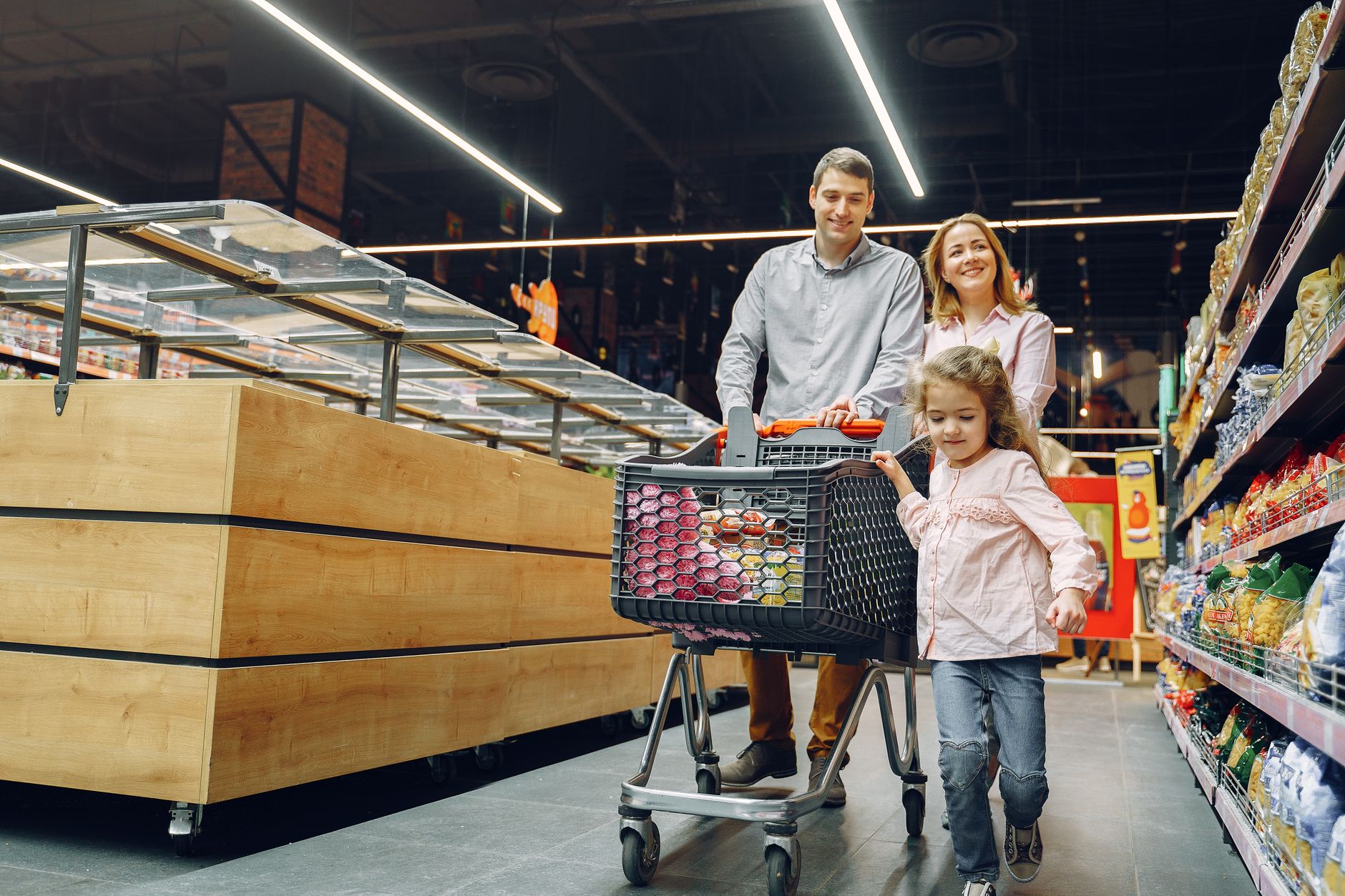 A joyful family shopping together in a supermarket aisle, enjoying their day.