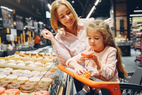 Mother Watching Her Child Eating Donut