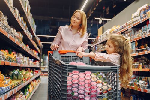 Free A mother and daughter enjoying time together shopping in a vibrant supermarket aisle. Stock Photo