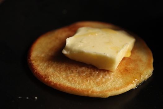 Pancake with melting butter on top creates a warm, inviting food image.